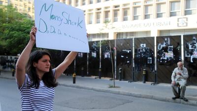 A protester holds a banner reading 'Money Shark' during a demonstration outside the Lebanese central bank, also known as Banque du Liban, in Beirut, Lebanon. Calls are mounting for Lebanon to impose formal restrictions on the movement of money to defend the country’s dollar peg and prevent a run on the banks when they open their doors on Friday after two weeks of nationwide protests. Bloomberg