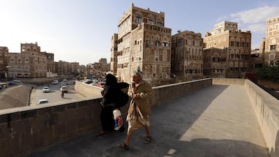 Yemenis walk past historical buildings in Sanaa, Yemen. EPA / Yahya Arhab