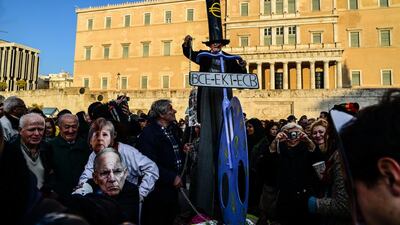 Protesters outside the Greek parliament in Athens, wearing masks of German chancellor Angela Merkel and finance minister Wolfgang Schäuble, front left, and, centre, a man rallies against the European troika. Getty Images