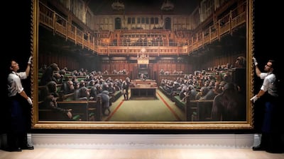 Gallery assistants pose with Banksy's "Devolved Parliament". AFP