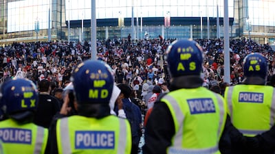 A line of police watch supporters outside Wembley Stadium ahead of the Euro 2020 final between Italy and England. AP