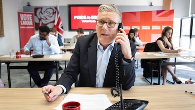 British Prime Minister Keir Starmer helps out in the call centre at Labour Party headquarters in London, on the last day of campaigning ahead of elections. PA