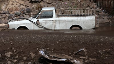A pick-up truck axle-deep in mud from a landslide in Emamzadeh Davoud. AP Photo