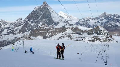 People wearing protective masks travel on a ski lift in the ski resort of Zermatt, Switzerland. Reuters