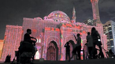 People taking photos of the Al Noor Masjid during the Sharjah Light Festival in Sharjah. Pawan Singh / The National