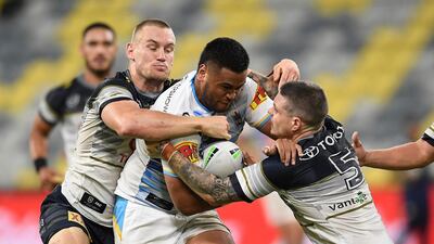 Sam Lisone of the Titans is tackled by Coen Hess and Ben Hampton of the Cowboys during the round three NRL match between the North Queensland Cowboys and the Gold Coast Titans at QCB Stadium in Townsville, Australia. Getty Images