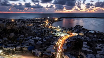 Light trails from vehicles moving through a displacement camp near the port in Gaza city, captured using a long exposure. AFP