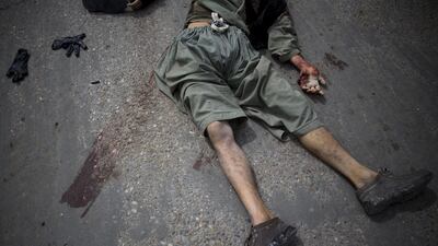 A dead suicide bomber lies on the street.