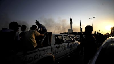 Smoke billows in the background as Libyan rebels overrun Libyan leader Moamer Kadhafi's fortified Bab al-Azizya headquarters in the capital Tripoli after heavy fighting on August 23, 2011. AFP PHOTO / FILIPPO MONTEFORTE