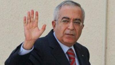 The Palestinian prime minister Salam Fayyad waves as he arrives for a meeting of the Palestine Liberation Organization after tendering his resignation to President Mahmoud Abbas' at Abbas' headquarters in the West Bank city of Ramallah, Sat March 7 2009.