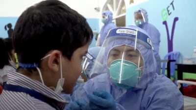 A pupil takes a Covid-19 saliva test at Al Rabeeh school in Abu Dhabi. Abu Dhabi Media Office