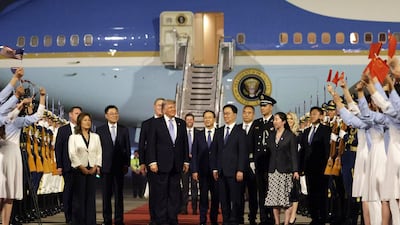 Donald Trump is welcomed in Beijing by 300 Chinese youths waving US and Chinese flags. Getty Images