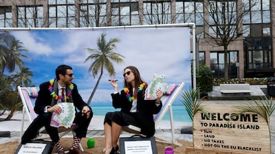 Campaigners outside a meeting of EU finance ministers in 2017 stage a protest on a mock tropical island beach representing a tax haven. Reuters