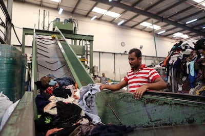 Workers sort through piles of clothing at a fabric recycling plant in Sharjah on October 22, 2014. Sarah Dea / The National