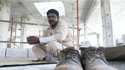Indian worker Nageshwar Rao lies on cardboard in the shade during the midday break at his construction site in Al Warqa, Dubai Pawan Singh / The National