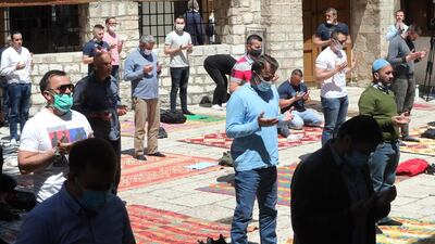 Bosnian Muslim men wearing protective face masks pray in front of the Gazi Husrev-beg Mosque in Sarajevo, Bosnia. EPA