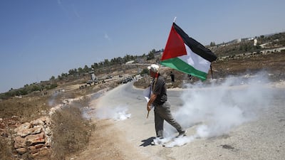 A protester holds a Palestinian flag in the West Bank village of Nabi Saleh. Reuters