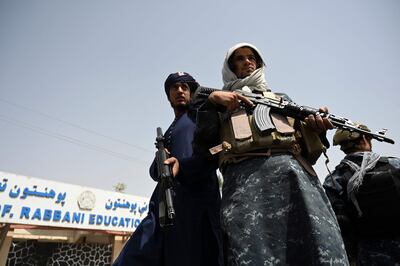 Taliban fighters escort veiled women marching during a pro-Taliban rally outside the Shaheed Rabbani Education University in Kabul. AFP
