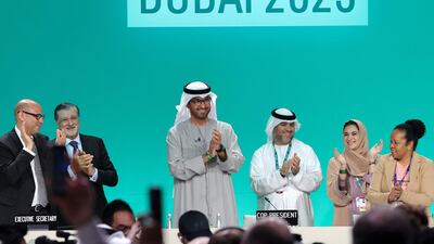 Cop28 President Dr Sultan Al Jaber applauds at the UN climate summit in Dubai on Wednesday where a deal was unanimously adopted. AFP