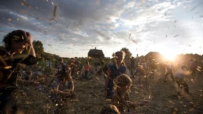 People dance and throw straw during a traditional festival in village Ozerco, some 10km from Minsk. Uladz Hrydzin / AFP