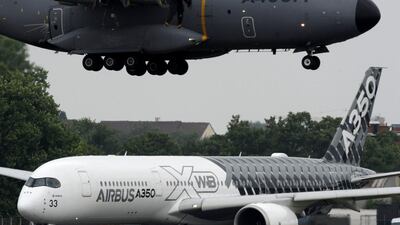 An Airbus A400M (top), whose engines were developed with Rolls-Royce expertise, is brought in to land as a Rolls-Royce powered Airbus A350 XWB prepares for take off at Le Bourget in Paris. Eric Piemont / AFP