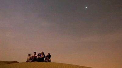 A family watches the Perseids meteor shower from atop a sand dune near Lehbab, midway between Dubai and Hatta.