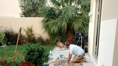 Andrew Field works on his seven-metre-long tea-leaves painting, which is on display at the Dubai Multi Commodities Centre in Almas Tower, JLT, Dubai. Courtesy Andrew Field