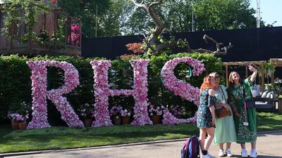 Visitors take a selfie with a floral display of the RHS logo. Reuters