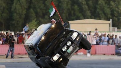 Haran Al Ghufli waves a UAE flag out of a Land Cruiser driven on two wheels by Mohammed Al Matlae at the Fast & Furious 6 "Extreme Car Park" event at Studio City in Dubai. Sarah Dea/The National