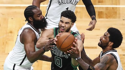 Jayson Tatum of the Boston Celtics drives to the basket while guarded by James Harden and Kyrie Irving of the Brooklyn Nets. AFP