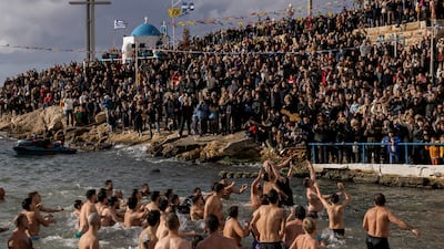 Orthodox Christians jump to catch a wooden crucifix during Epiphany celebrations in Piraeus, Greece. Reuters