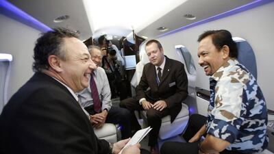Brunei’s Sultan Hassanal Bolkiah, right, and Singapore’s defence minister Ng Eng Hen, second left, speak with representatives of Pilatus in a mock up of their PC-24 aircraft cabin at the Singapore Airshow. Edgar Su / Reuters