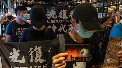 Pro-democracy supporters hold banners and shout slogans as they march in a shopping mall during a lunch protest in Hong Kong, China. Getty Images