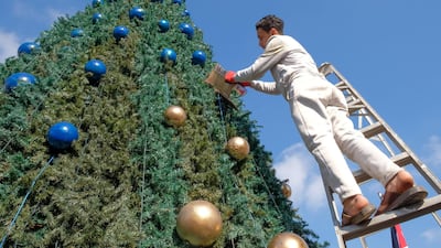 Young labourer, Hussam, re-paints the ornaments of the Christmas tree in Fuheis, a predominantly Christian town in Jordan. Amy McConaghy / The National