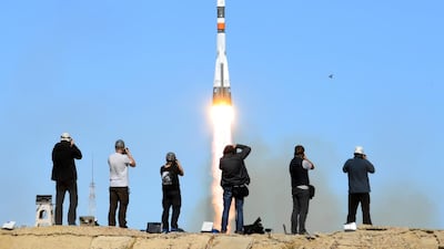 Photographers take pictures as the Soyuz spacecraft blasts off. AFP