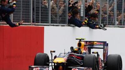 Sebastien Vettel drives towards the pit-wall where his team cheer him to victory at the British Grand Prix at Silverstone.