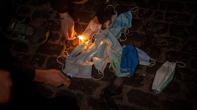 Demonstrators burn their masks during a protest before clashing with police in downtown Barcelona. AP Photo