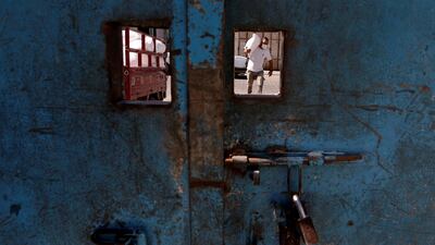 A worker is seen through an opening in a school door as he carries a sack of flour distributed by UNRWA to be delivered to a Palestinian family amid the coronavirus outbreak, in Gaza City. Reuters