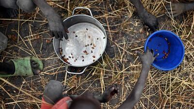 Children collect spilt grain following a World Food Programme food drop in Ayod county, South Sudan, February 6, 2020. AFP