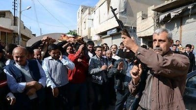 A Syrian rebel fires shots during the funeral of Mohammed Hafar, 20, in the northern Syrian town of Azaz. Mr Hafar and his brother were killed during clashes between Kurds and Free Syrian Army fighters near the village of Al Kastal close to the border with Turkey, amid rising communal tensions.