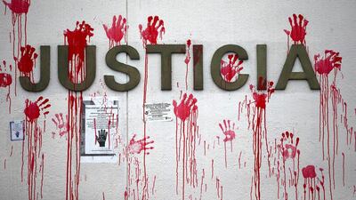 Red handprints cover the word “Justice” on the outside wall of the Supreme Court building during a protest by human rights activists in Guatemala City. Moises Castillo / AP Photo