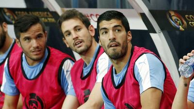 Injured Uruguay forward Luis Suarez, right, sits on the sideline with teammates Alvaro Gonzalez, left, Cristhian Stuani, middle, prior to a Copa America group C match against Mexico at University of Phoenix Stadium, Sunday, June 5, 2016, in Glendale, Ariz. (AP Photo/Ross D. Franklin)