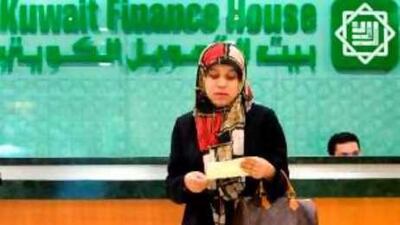 Ring it up: a customer leaves after completing a transaction in Kuala Lumpur, Malaysia. The bank may soon start activities in Paris.