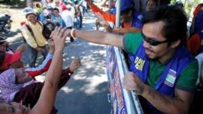 Manny Pacquiao reaches out to potential voters while on the campaign trail in the Philippine elections.