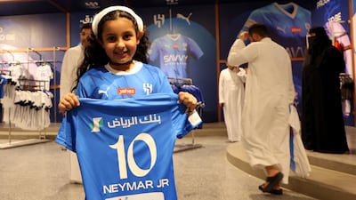 A young fan poses with a Neymar Al Hilal shirt in the club shop. Reuters