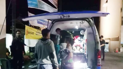 People are seen next to the ambulance near the Golden Palace Hotel after an earthquake hit Lombok Island. Yayan Kopi / Reuters