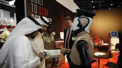 Visitors to the Gulf Information & Security Expo and Conference get acquainted with Dubai’s Robocop. Anna Nielsen for The National
