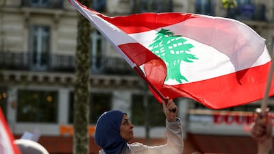 A protester waves a Lebanese flag during a rally in Paris on Sunday. Further support for Lebanon’s legitimate armed forces and more help with the country’s humanitarian crisis would buttress the talks process taking place in Washington. AFP