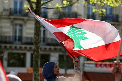 A protester waves a Lebanese national flag during a rally in support of Lebanon at Place de la Republique, in central Paris. AFP