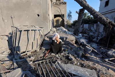 A Palestinian woman reflects on the horrors of the Gaza war outside buildings destroyed by Israeli forces in Deir Al Balah on Wednesday. Reuters